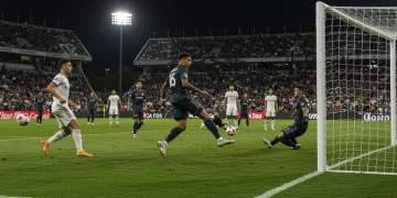 Soccer player scoring a game-winning goal in an MLS match, stadium lights, crowd cheering.