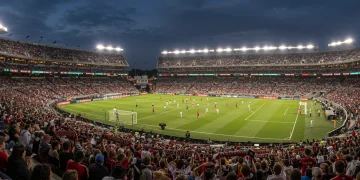 Packed MLS stadium with passionate fans cheering during a night game, showcasing vibrant fan culture and engagement.