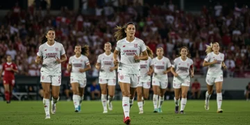 Dynamic image of female soccer players celebrating on a vibrant stadium field, representing NWSL growth.