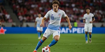 Young American male soccer player in US national team jersey dribbling