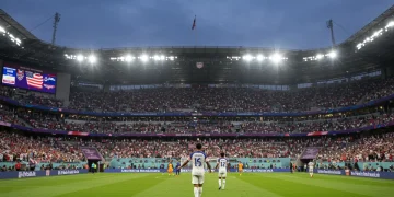 Dynamic image of a US soccer player celebrating a goal in a packed 2026 stadium, representing iconic moments.