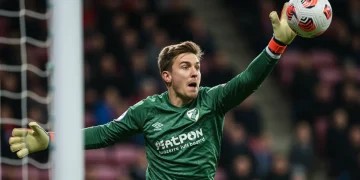 Goalkeeper making a dynamic save during a match, showing intense focus and athleticism.