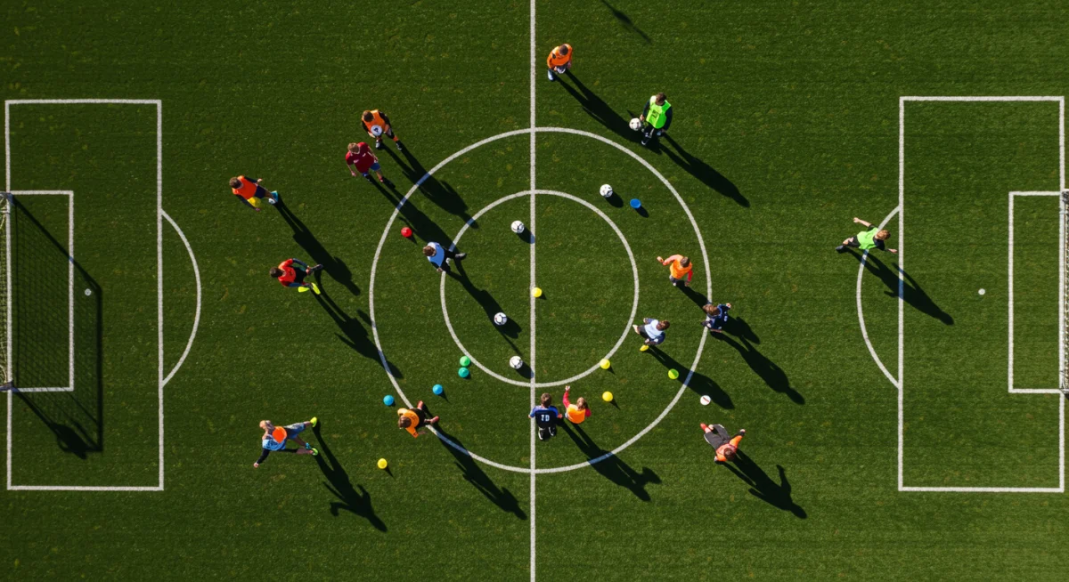Overhead view of young soccer players performing complex passing drills during a training session.